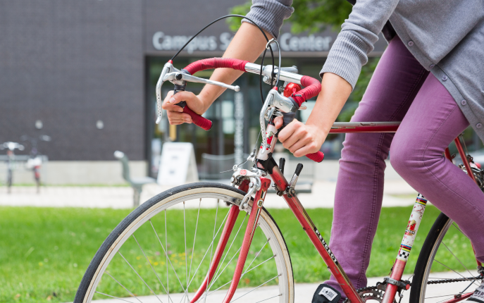 Symbolisch: Fahrradfahrerin vor dem Gebäude 40